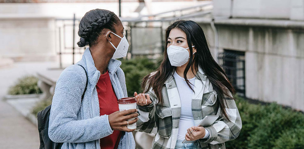 Two teenage girls wearing masks